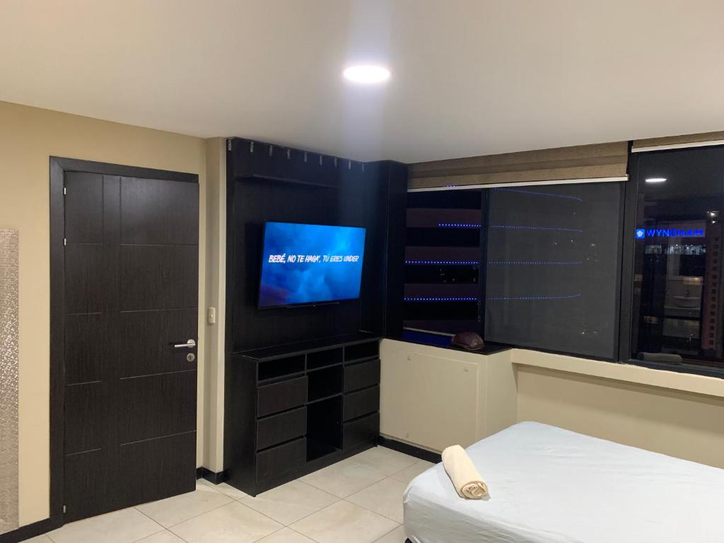 a room with a bed and a tv in a room at Puerto Santa Ana, Torres Bellini, 2 dormitorios, Parqueo in Guayaquil