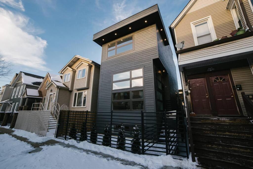 a house with a red door in the snow at MAGNIFICENT NEW Home w/8 Beds & Free Parking in Chicago