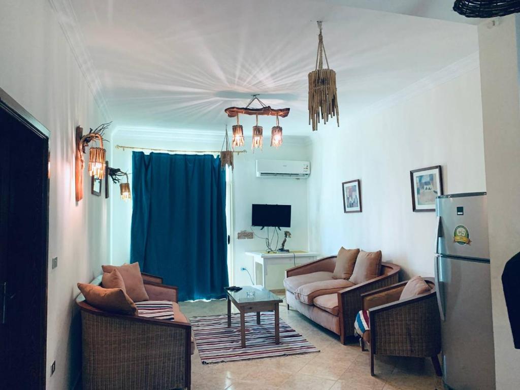 a living room with two couches and a blue curtain at Luna House Lighthouse in Dahab
