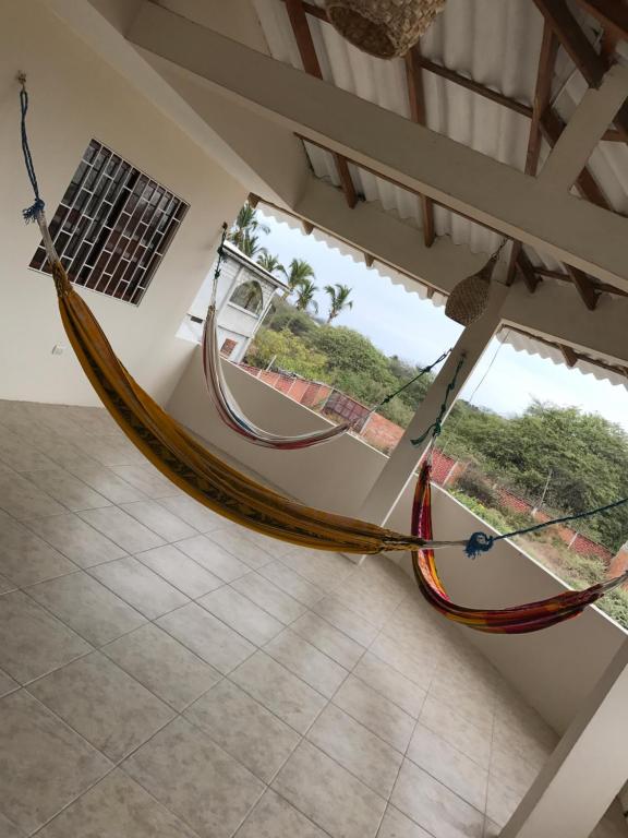 uma rede pendurada num quarto com uma janela em Suites Playas em Data de Villamil