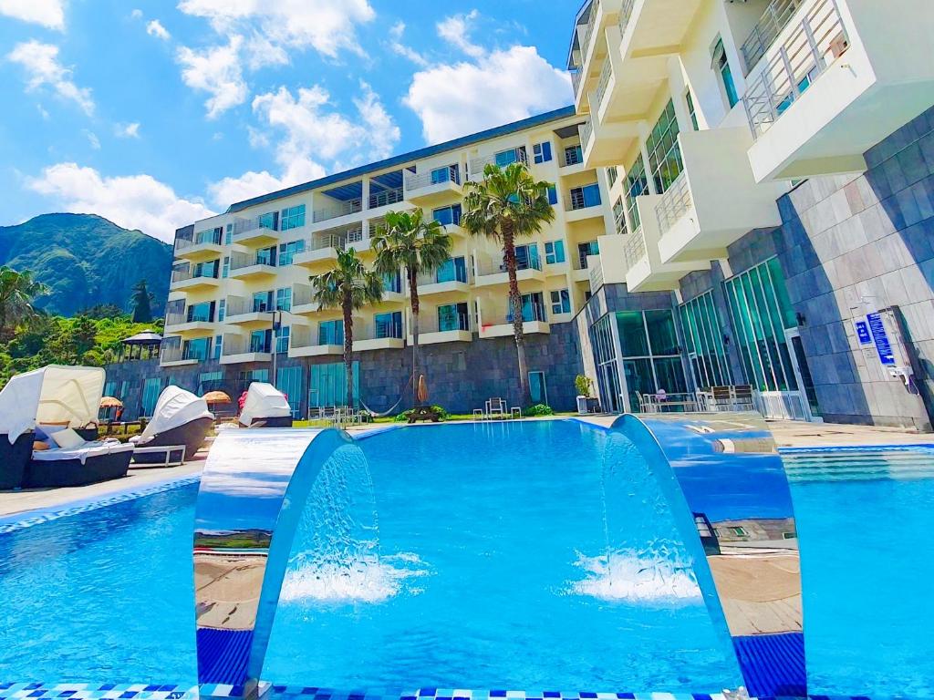 a large swimming pool in front of a building at Y Resort Jeju in Seogwipo