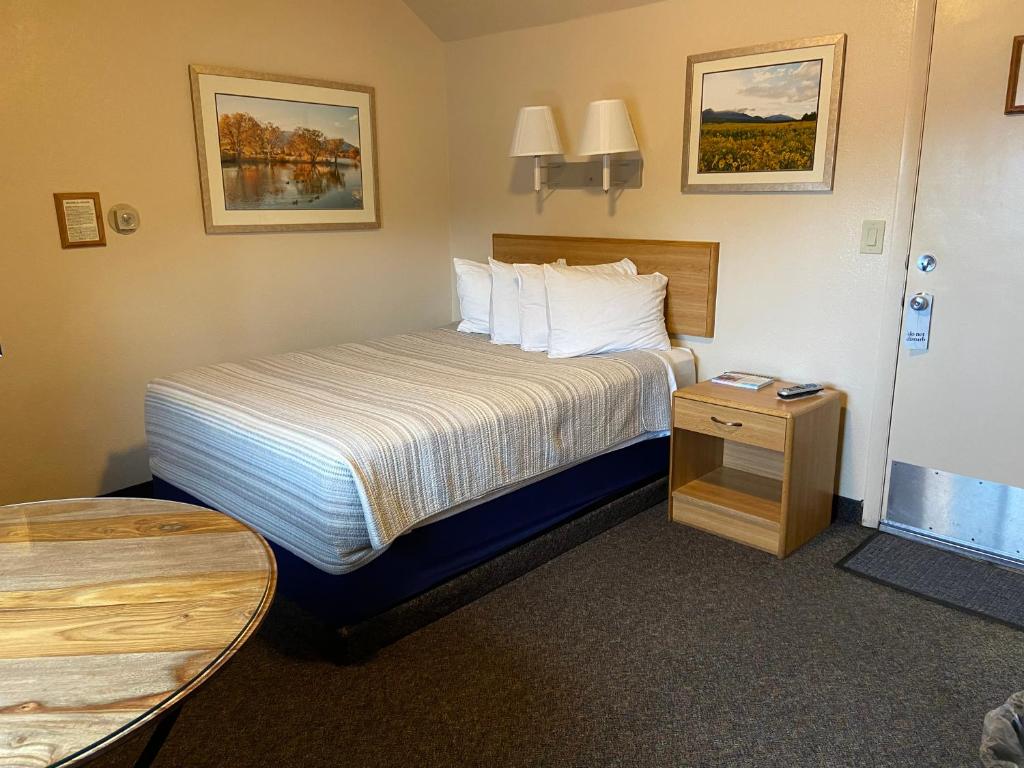 a hotel room with a bed and a table at Woodland Motel in Salida