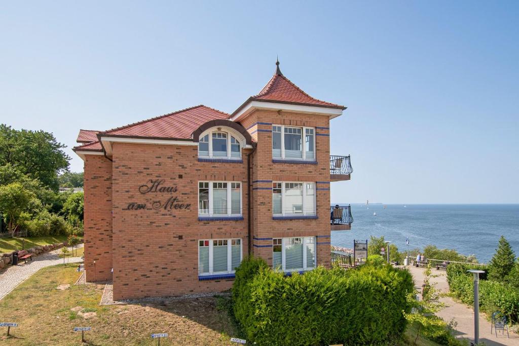 um edifício de tijolos com o oceano ao fundo em Ferienwohnung mit traumhaftem Meerblick - Haus am Meer FeWo 07 em Lohme