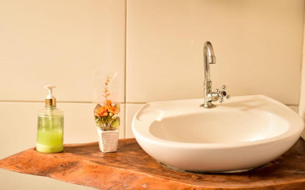 lavabo blanco sentado en una encimera de madera en el baño en Pousada Nossa Senhora da Guia en Nobres