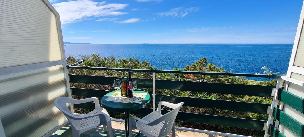 a balcony with a table and two chairs and the ocean at Apartments Ana i Ante Punta in Milna