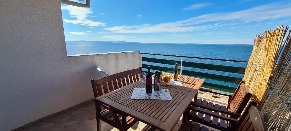 a table on a balcony with a view of the ocean at Apartments Ana i Ante Punta in Milna