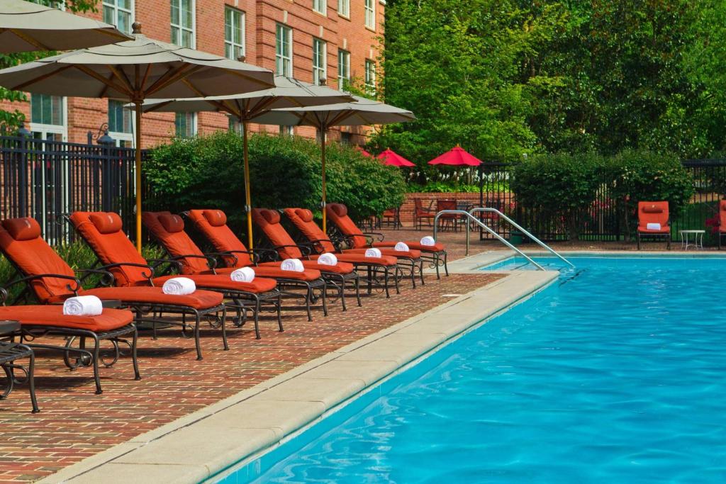 a row of chairs and umbrellas next to a swimming pool at Westfields Marriott Washington Dulles in Chantilly