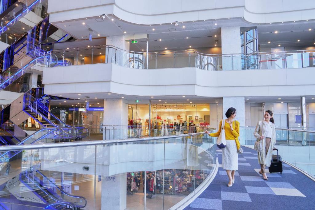 two women walking down an escalator in a shopping mall at Shin Yokohama Prince Hotel in Yokohama