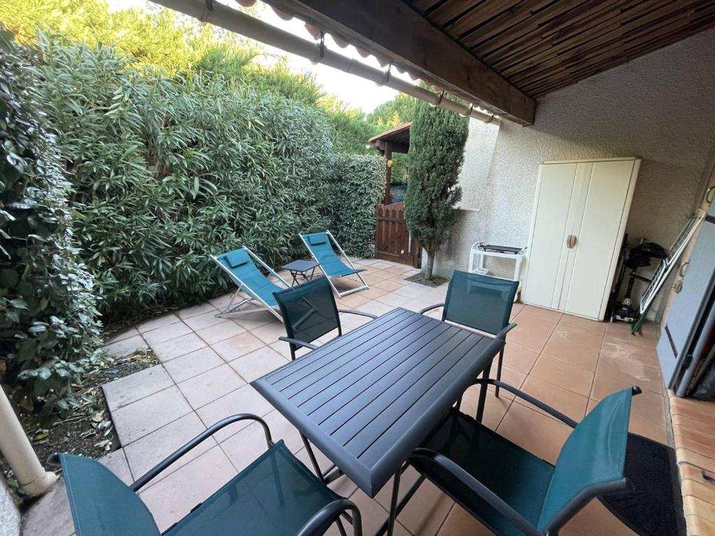 un patio avec une table et des chaises sur un patio dans l'établissement Villa calme à Agde, proche plage, avec terrasse ombragée et parking privé - FR-1-723-101, au Cap d'Agde