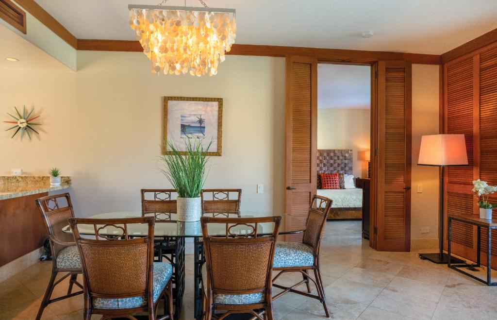 a dining room with a table and chairs and a chandelier at Mauna Lani Terrace G102 - Lagoon View Terrace Suite - Upscale Luxury Waterfront in Waikoloa