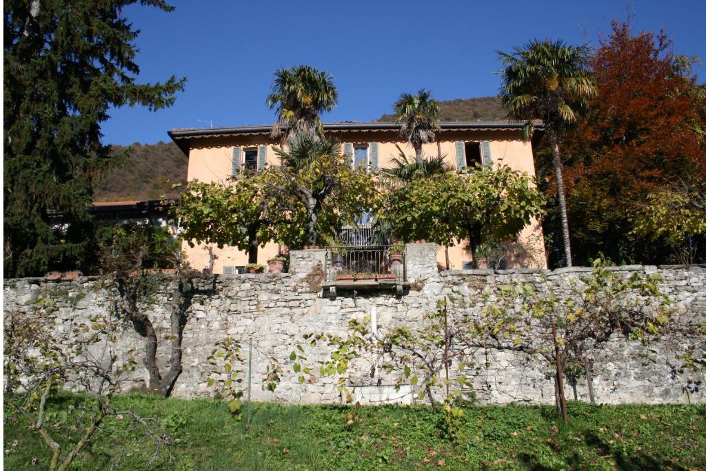 ein Haus auf einer Steinmauer in der Unterkunft Antico Glicine B&B in Maslianico