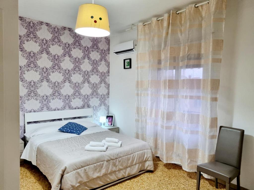 1 dormitorio con 1 cama y 1 silla en The Prime B&B, en Pisa