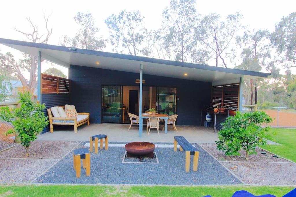 a house with a patio with a table and benches at Panda's Patch Dunsborough in Dunsborough