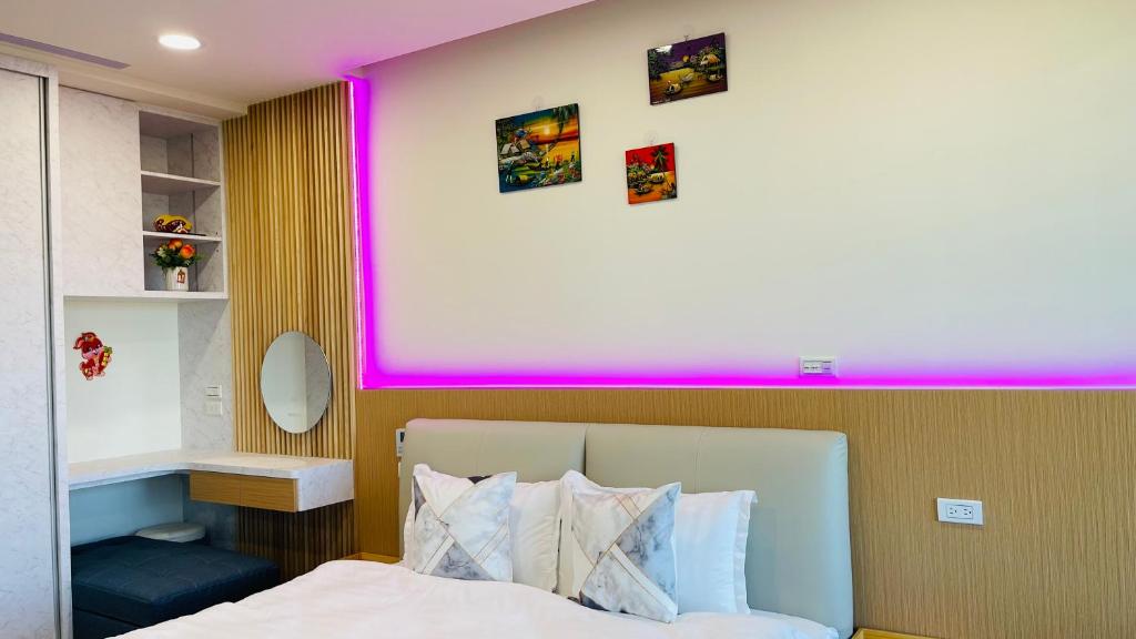 een slaapkamer met een bed met een roze muur bij 宜蘭頭城鎮 Alice 高級溫泉雙-四人套房海景度假 in Hsin-hsing