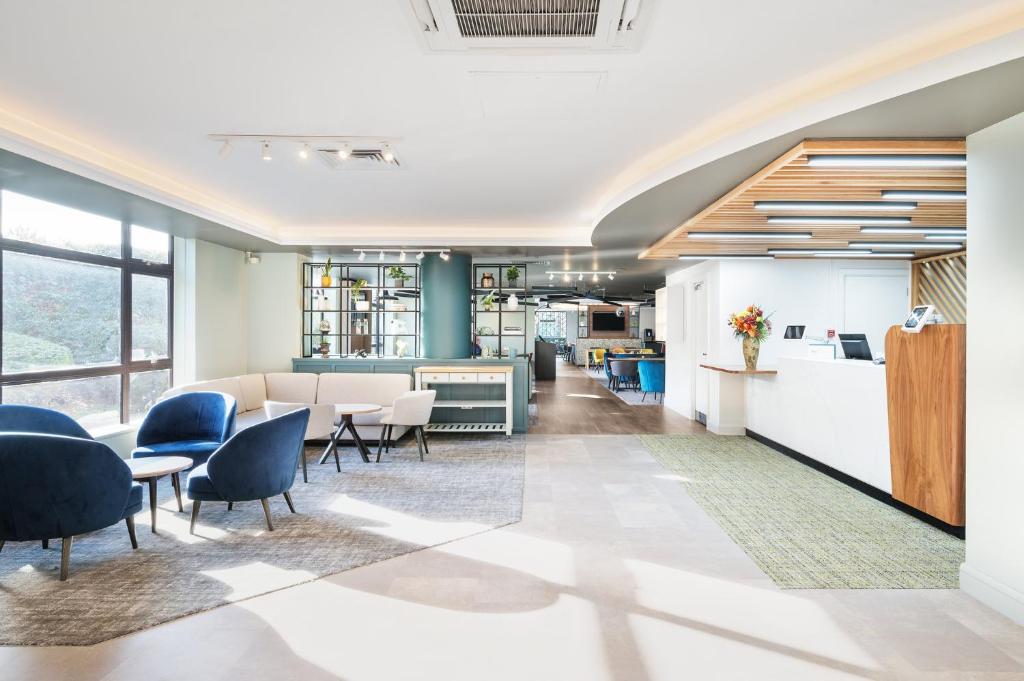 an office lobby with chairs and tables and a counter at Holiday Inn Rochester-Chatham, an IHG Hotel in Chatham