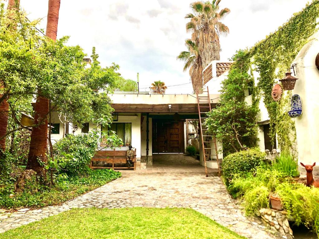 an old house with a driveway and palm trees at Hotel boutique Arteaga in Arteaga