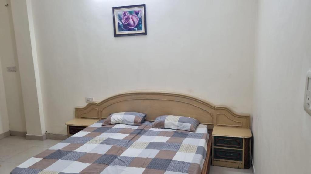 1 dormitorio con 1 cama con 2 almohadas en The Royal Elite Guest House, en Jalandhar