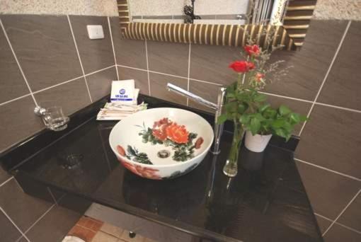 a bowl on a table with a vase and flowers at Green Window Homestay in Hualien City