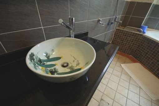 a sink on a black counter in a bathroom at Green Window Homestay in Hualien City