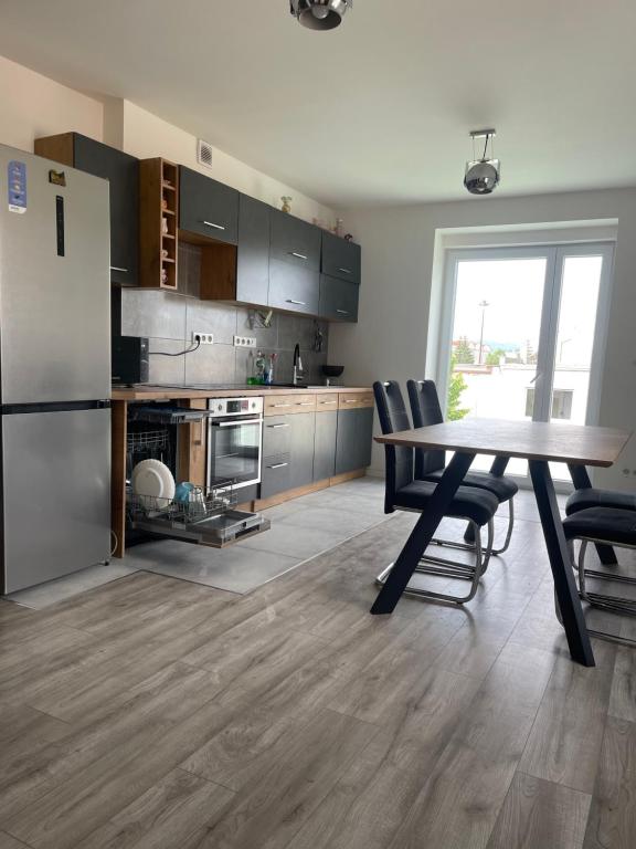 eine Küche mit einem Tisch und Stühlen sowie einem Kühlschrank in der Unterkunft Komfortné bývanie s garážou - parkovaním in Žilina