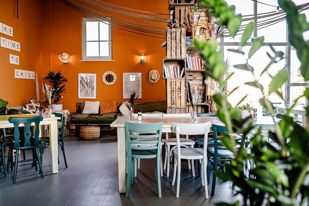 a dining room with orange walls and a table and chairs at TinyParks Eiland Tiengemeten in Zuid-Beijerland