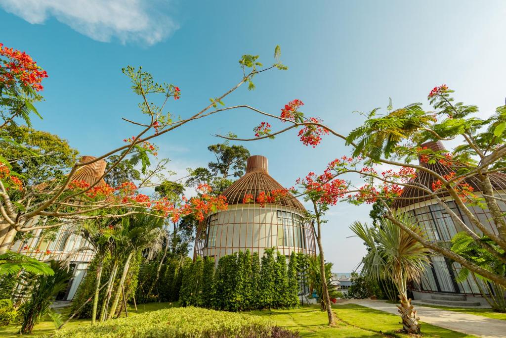 a greenhouse in a garden with red flowers at Bird Nest Villas by Mafiya in Sihanoukville