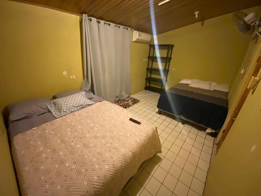 a small room with two beds and a window at La Casa de Cachi in Paquera