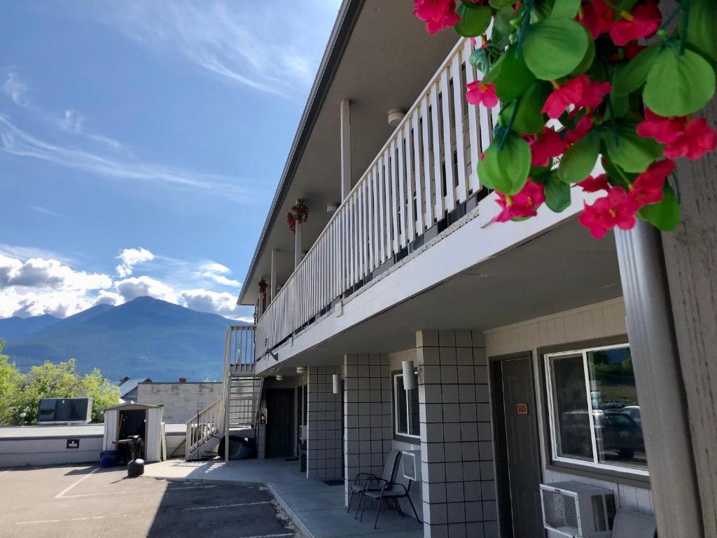 a building with a balcony with pink flowers at The Canterbury Inn of Downtown Invermere in Invermere
