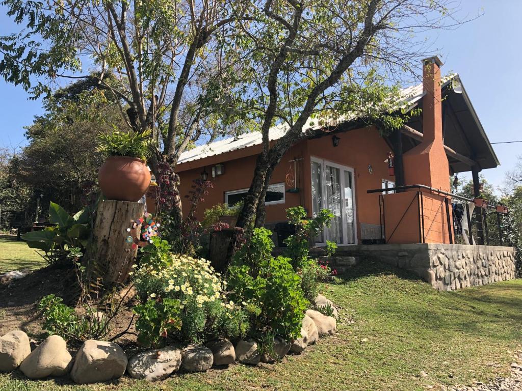 a house with a flower garden in front of it at Nature, comfort, and authenticity in the Salta countryside in Vaqueros