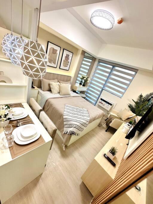um quarto com uma cama e uma mesa num quarto em Aurum Latte Suite at Azure North em Lagundi