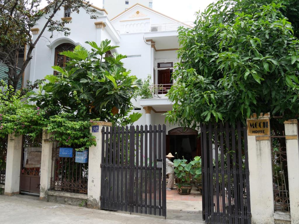 ein Tor vor einem weißen Haus mit Bäumen in der Unterkunft Moon house tropical garden - Coconut in Nha Trang