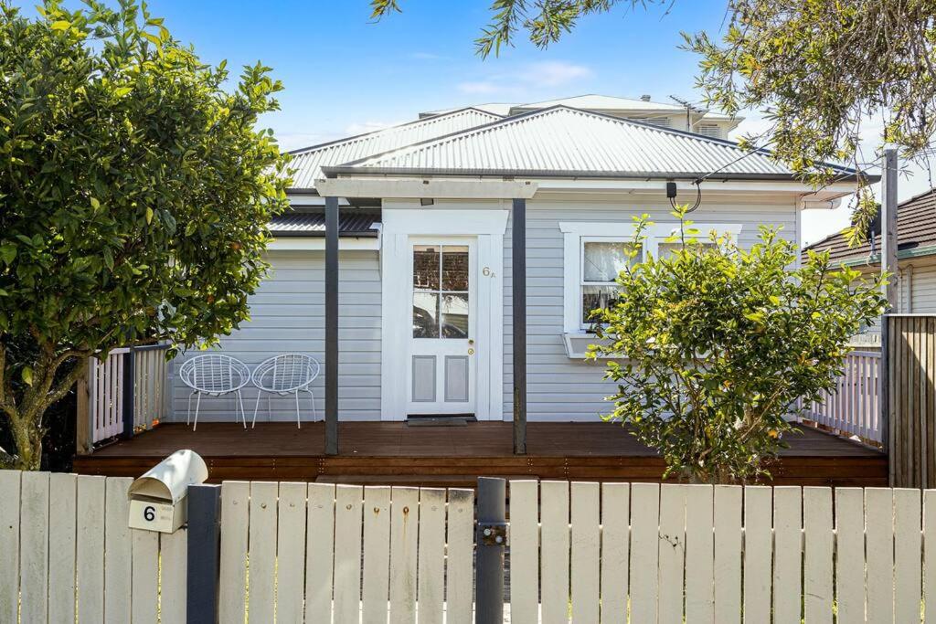 a white house with a fence in front of it at 2-bedroom Cottage in Redcliffe - 6A in Redcliffe