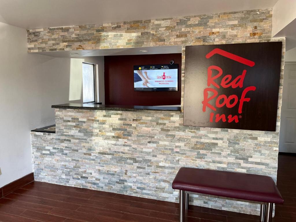 a bar with a red roof sign on a brick wall at Red Roof Inn Kimball, TN I-24 in Kimball