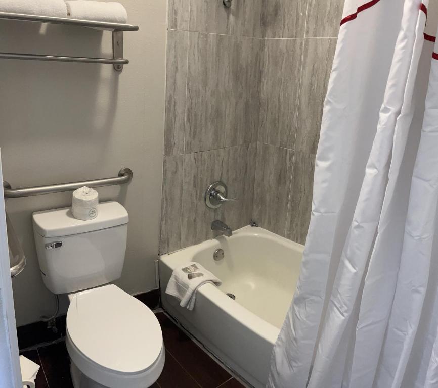 a bathroom with a white toilet and a bath tub at Red Roof Inn Kimball, TN I-24 in Kimball