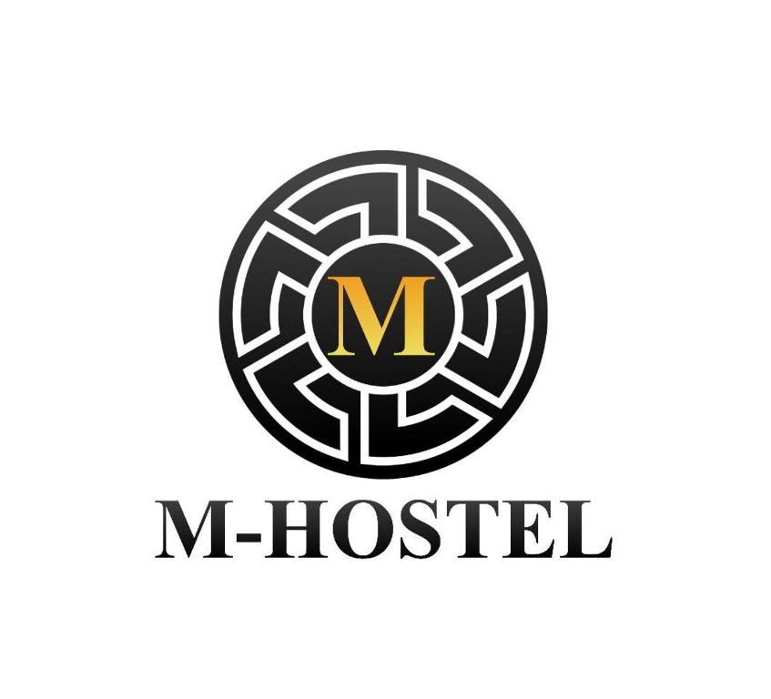 un logo pour un musée avec une lettre m en cercle dans l'établissement M-Hostel, à Lucerne
