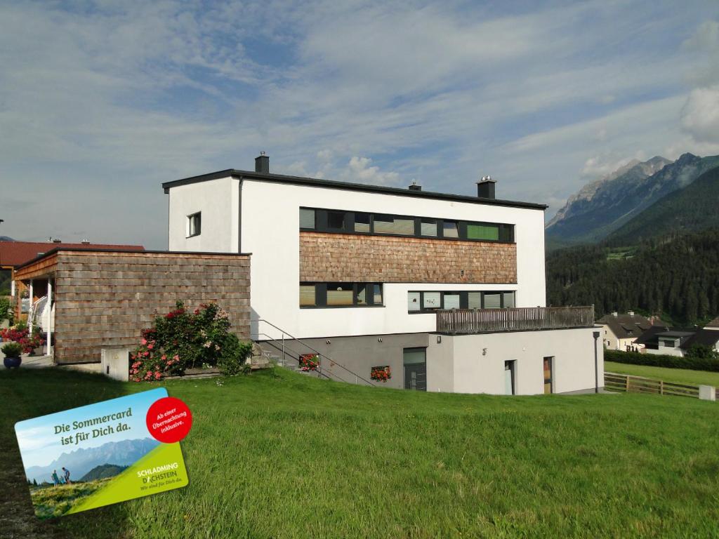 una casa en una colina con un cartel delante en Appartement Gipfelsturm, en Haus im Ennstal