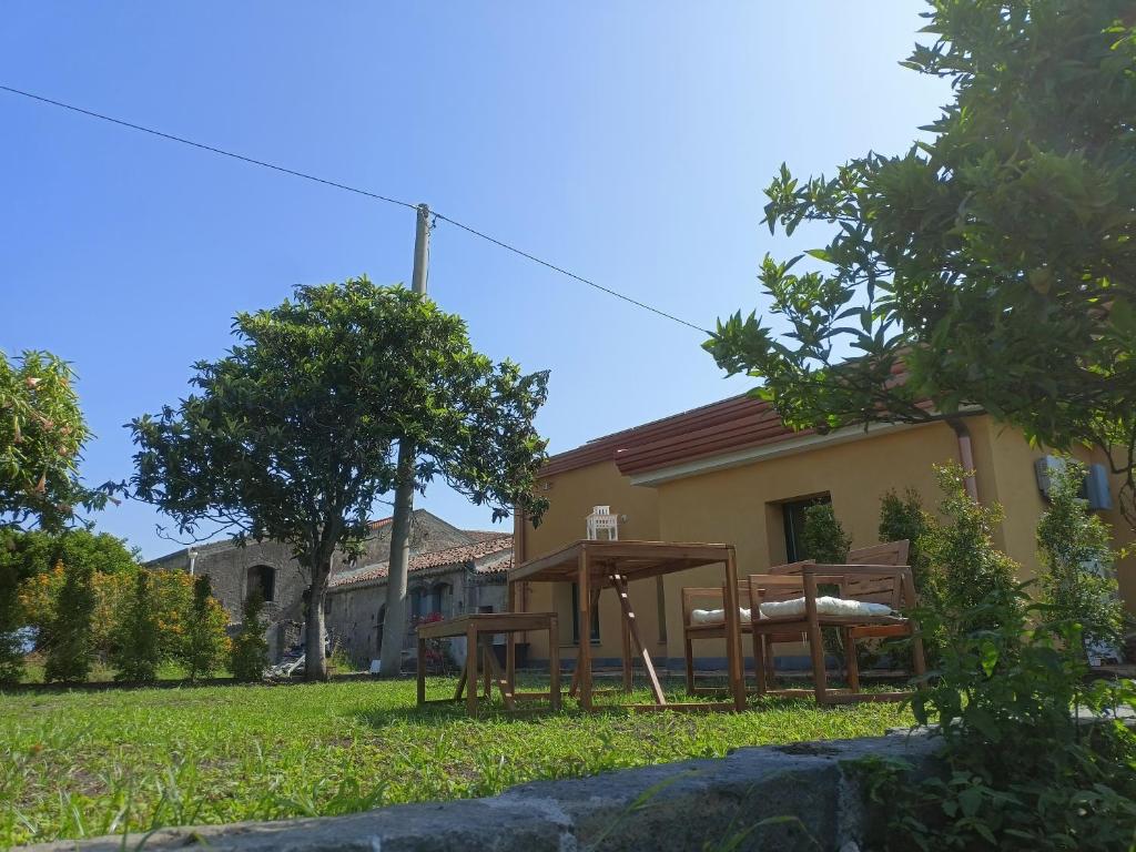 - une table et des chaises dans la cour d'une maison dans l'établissement Giardino Arancio - casa vacanze, à Giarre