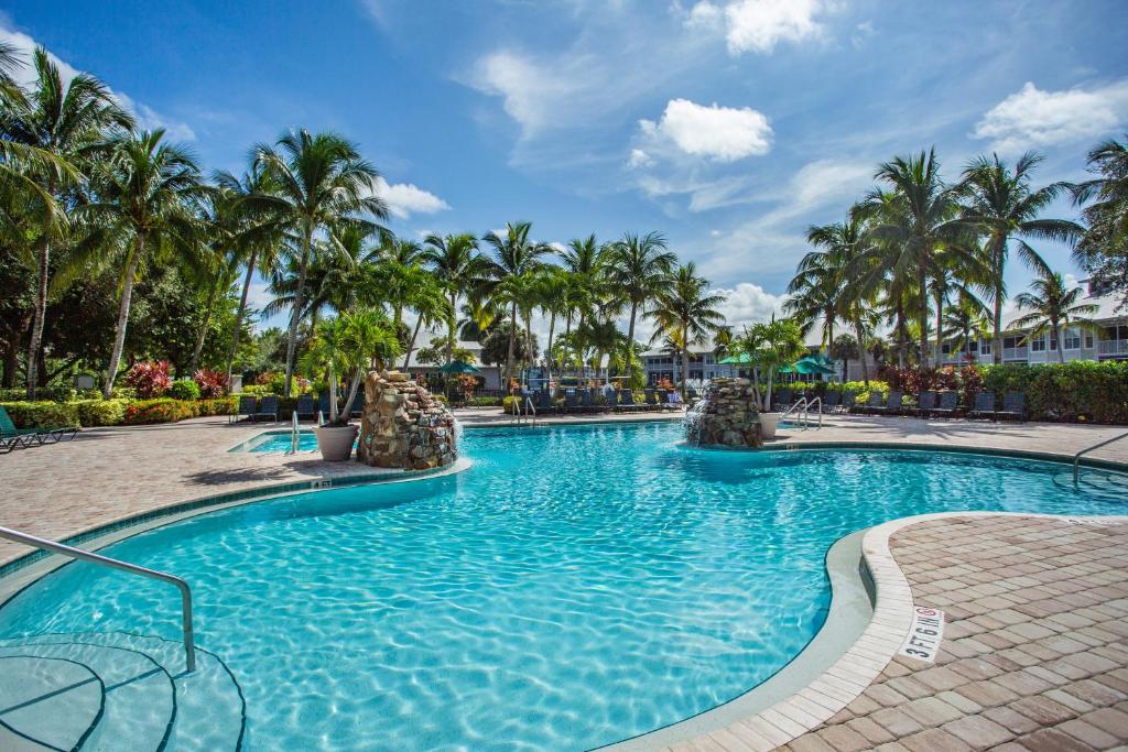 a swimming pool at a resort with palm trees at Solterra Golf Condo at the Lely Resort in Naples