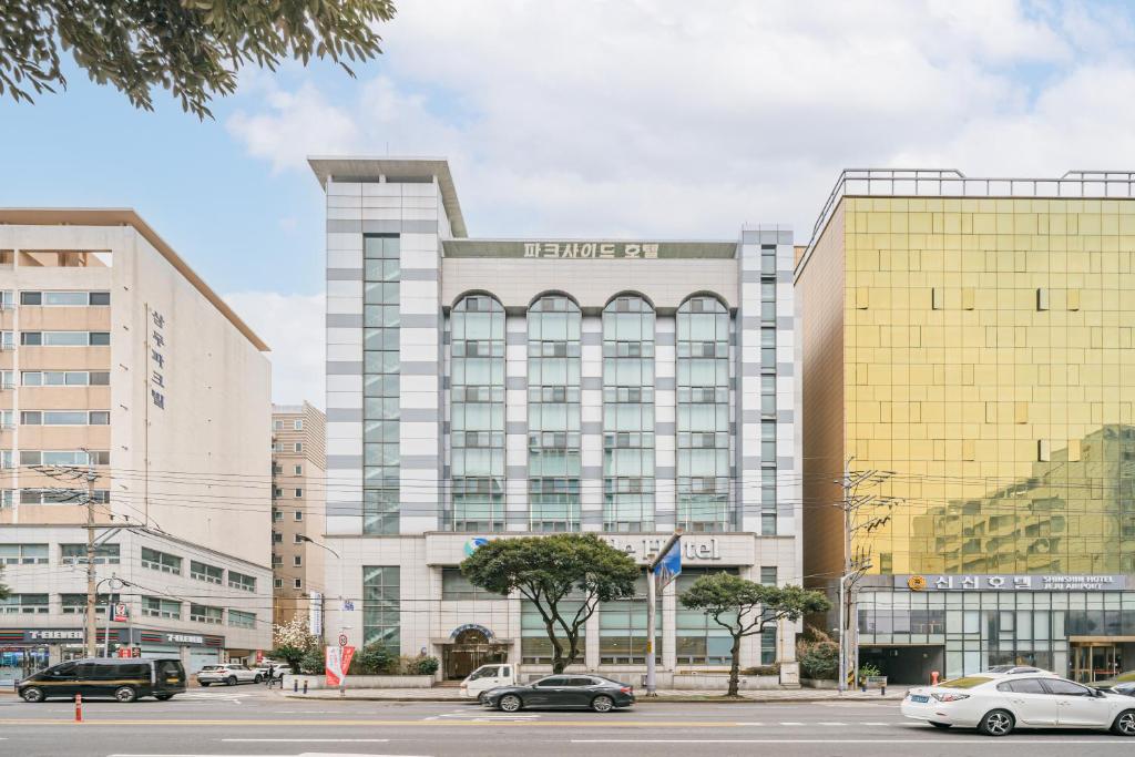 um grande edifício com carros estacionados em frente em Jeju Parkside Tourist Hotel em Jeju