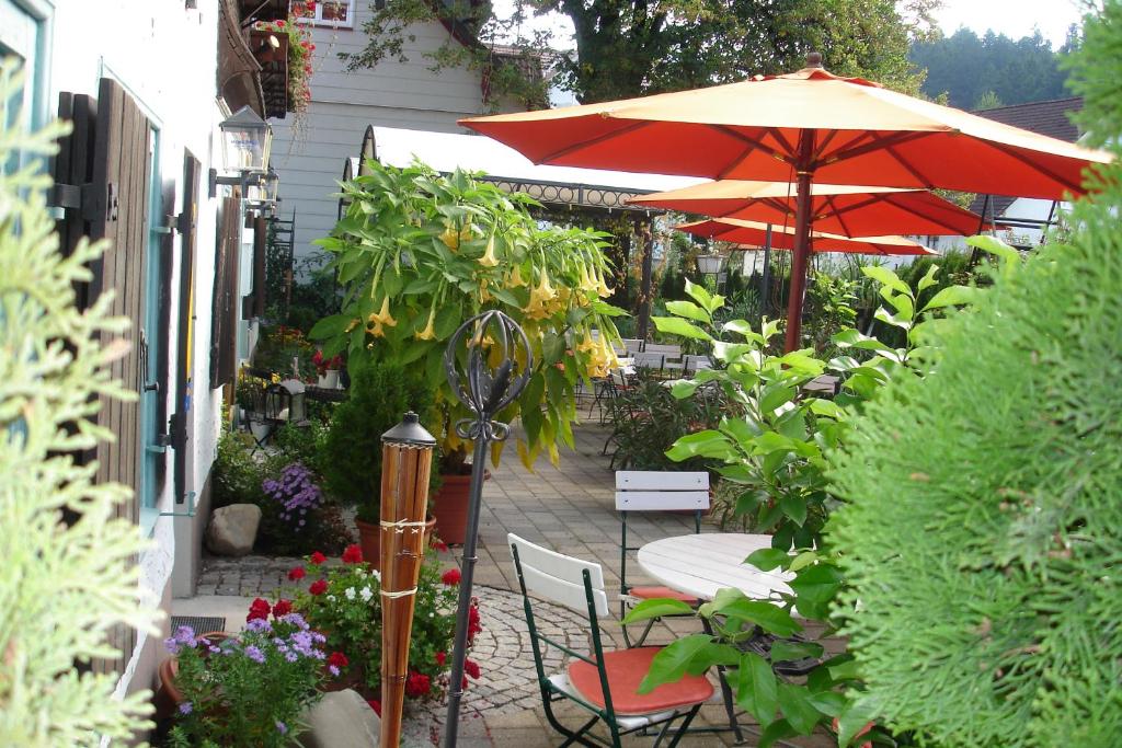 a patio with a table and an umbrella and chairs at Landhaus Goldenes Kreuz in Leutkirch im Allgäu