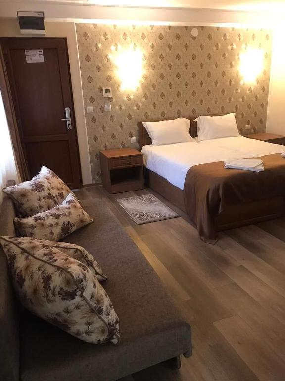 Habitación de hotel con cama y silla en Pensiunea Casa Coroana, en Orăştie