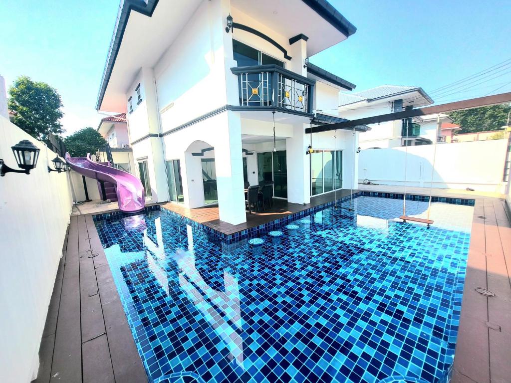 a swimming pool in front of a house at Eldorado pool villa 6br in Jomtien Beach