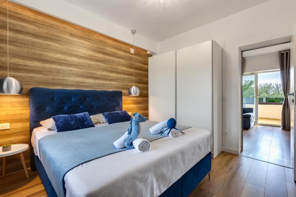 Un dormitorio con una cama azul con un osito de peluche. en TEONA Luxury Apartment with terrace, en Sali