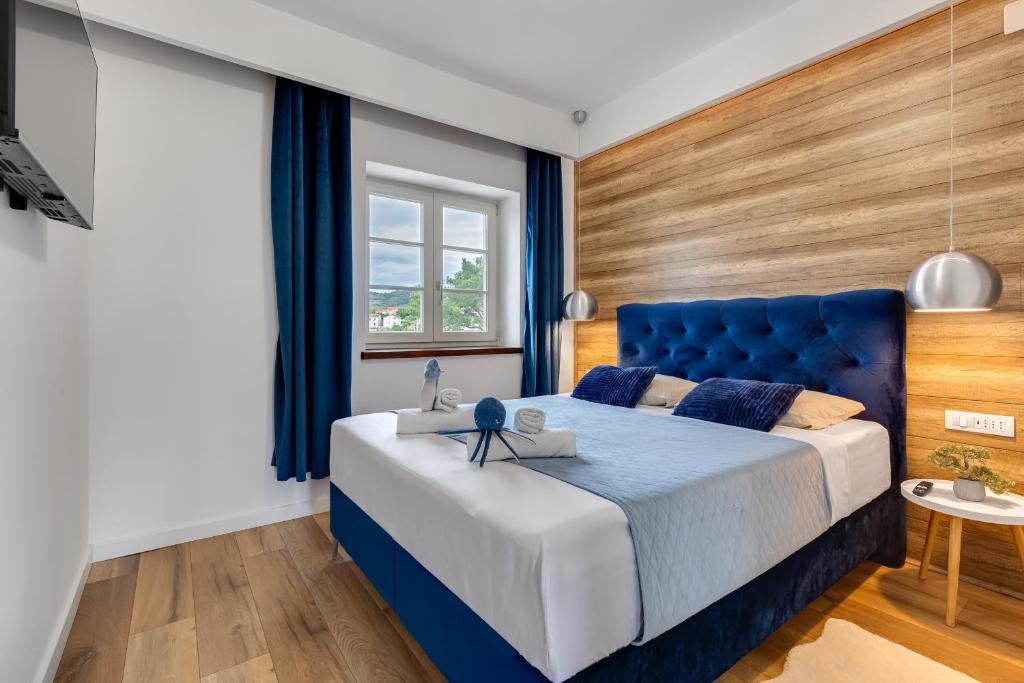 a bedroom with a blue bed and a window at TEONA Luxury Apartment with terrace in Sali