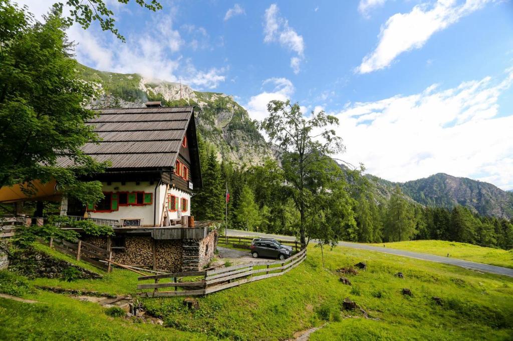 a house with a car parked next to a road at Tonkina koča in Kranjska Gora