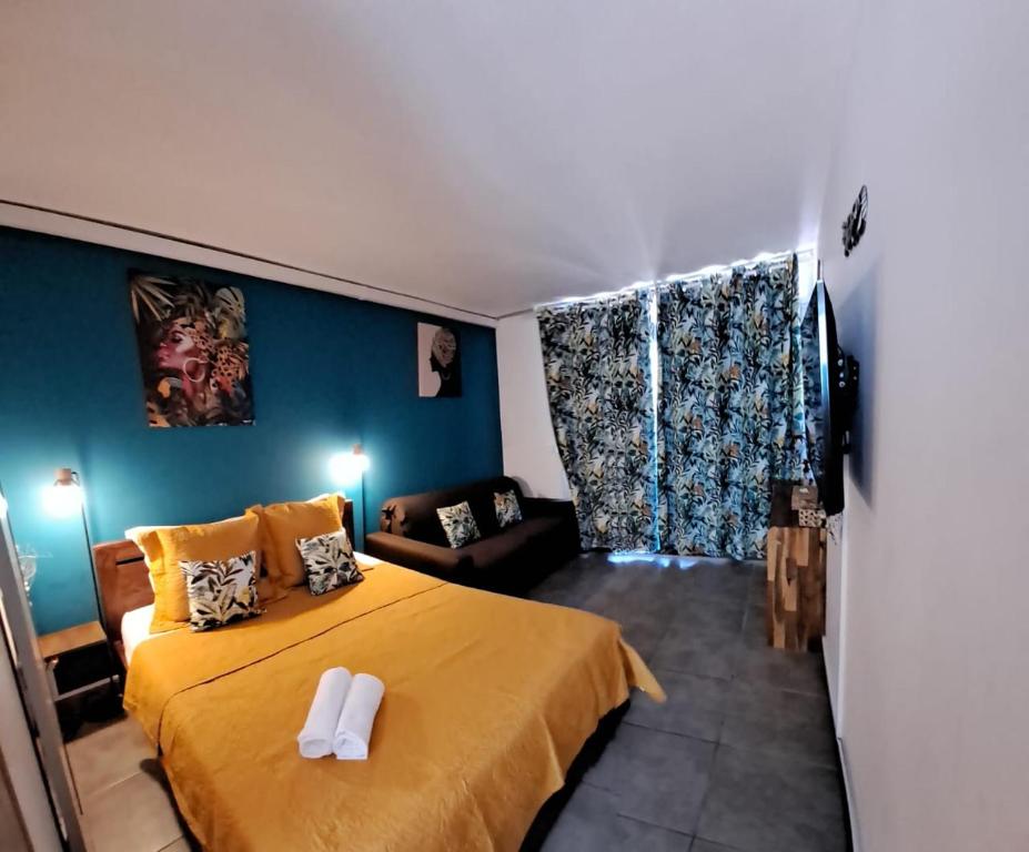 um quarto com uma cama amarela e um sofá em Blue Dream em Le Diamant