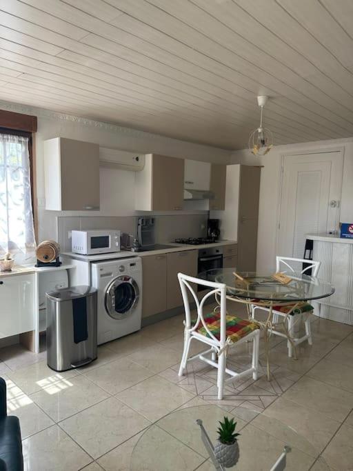 a kitchen with a table and a table and chairs at L'art de vivre conjugué au calme in Balloy