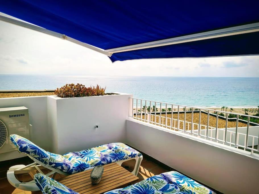 Un balcón con sillas y vistas al océano. en Residential Oasis 25, en Mojácar