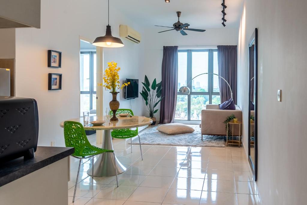 a living room with a table and green chairs at Tropics Condo in Petaling Jaya