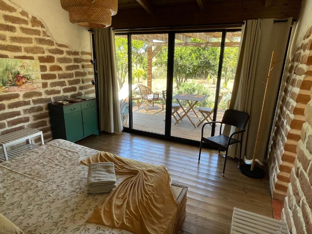 a bedroom with a bed and a brick wall at SeaHouseNature in Porto Covo